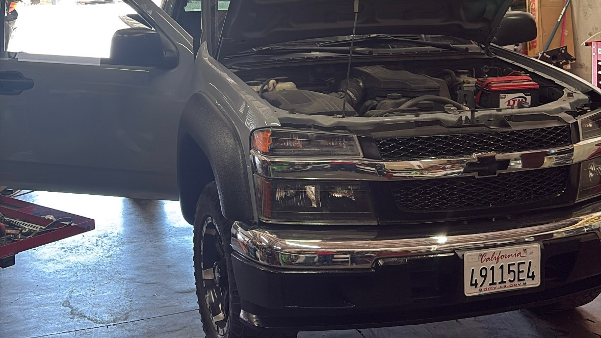 Chevy with hood open in service bay